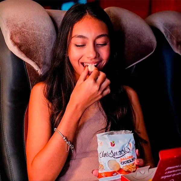 Passageira comendo Balões de Queijo UniSnacks no serviço de bordo